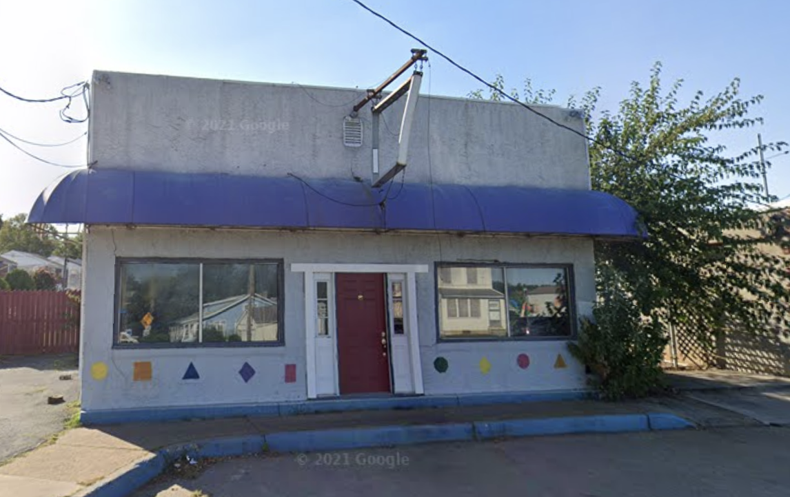 Gray building with a blue awning that once housed a day care center