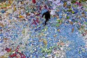 Chinese officer walking over a mountain of fake medicines