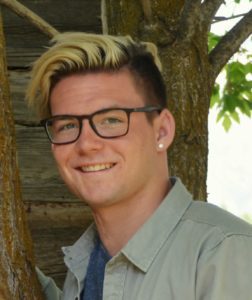 Man with glasses in front of tree