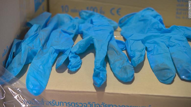 3 or 4 dirty blue medical gloves on a cardboard box