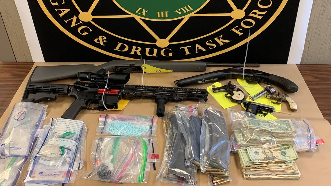 guns and drugs in plastic bags on a table