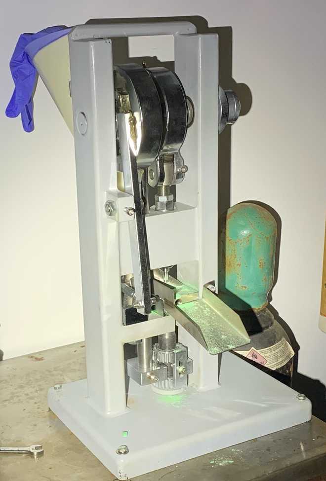 image of a pill press with green powder residue