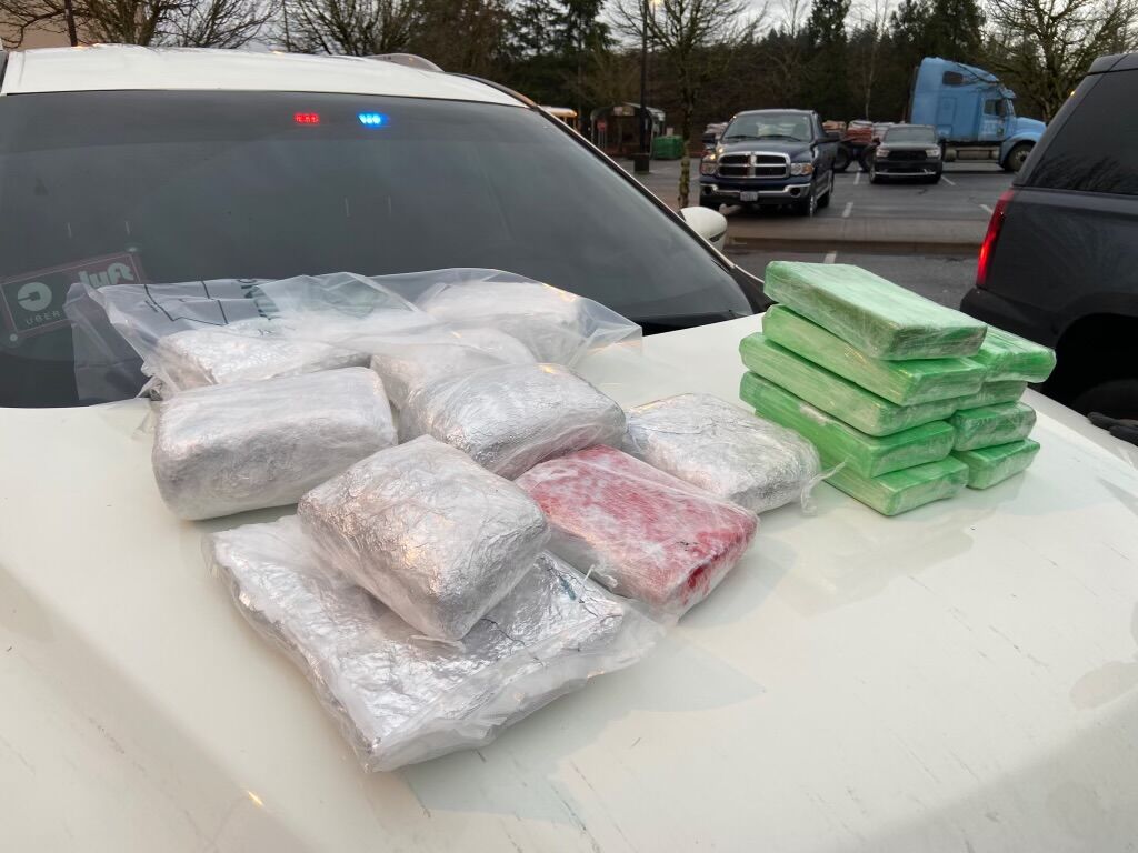 drugs bundled in rectangular plasitc bundles, set out on the hood of a car