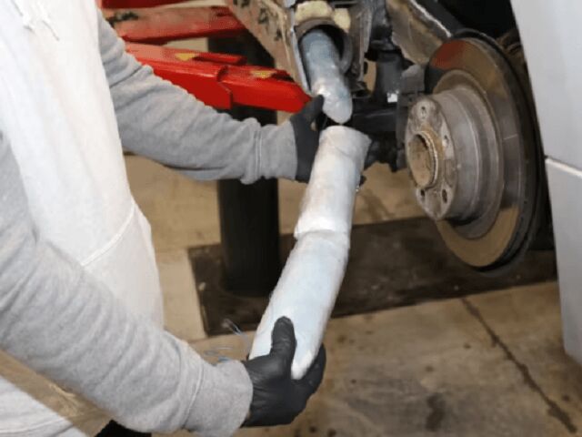 arms removing cylinders of fentanyl pills from a car