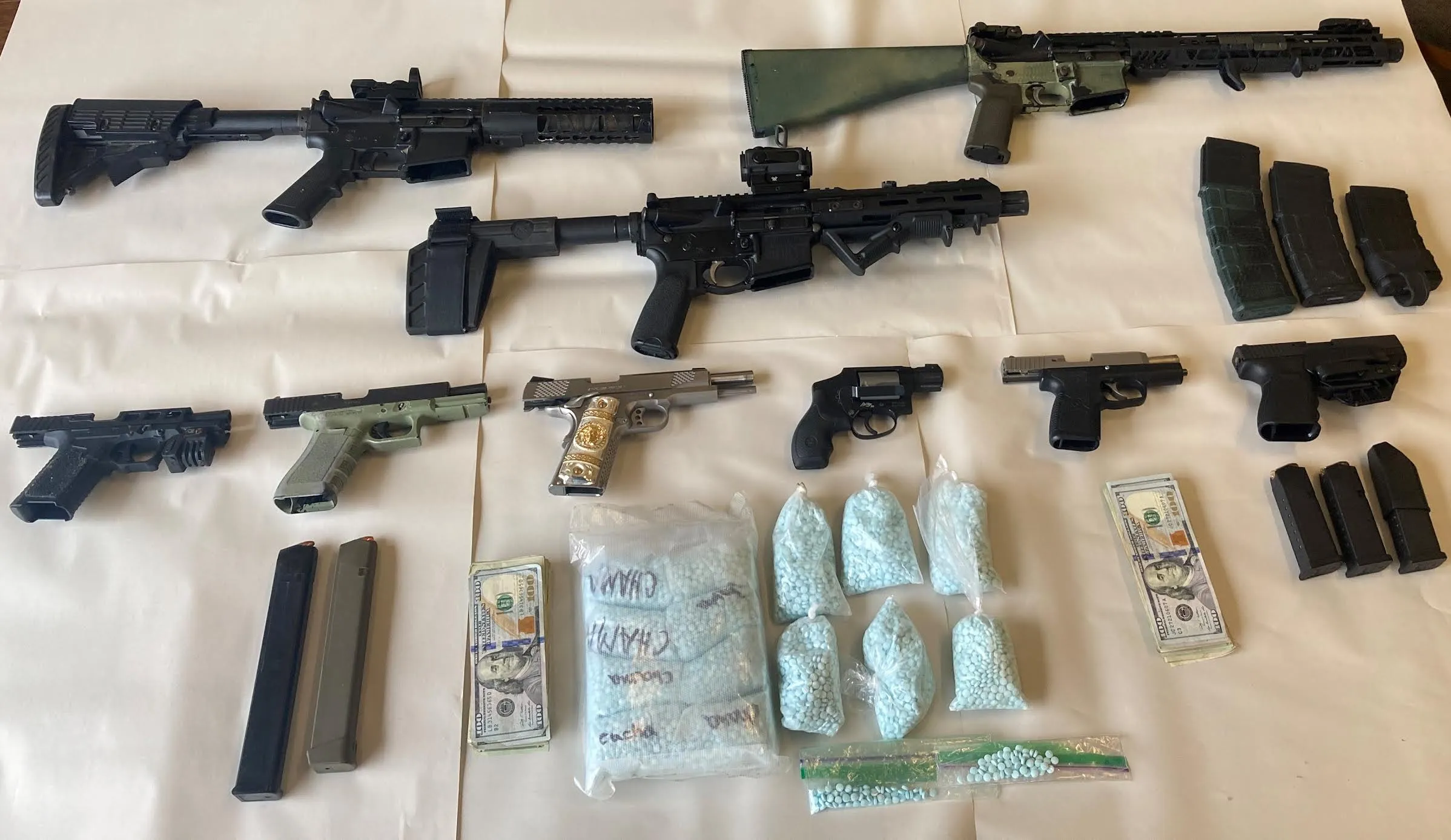 drug seizure imae with firearms and blue pills