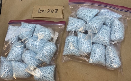 2 images of stacks of blue pills in clear plastic bags