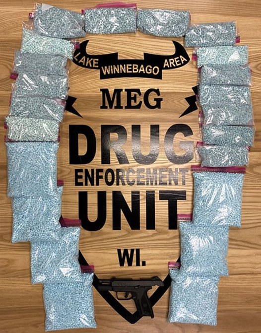 Blue pills in clear bags wit a sign on top of them: Lake Winnebago Area MEG Drug Enforcement Unit WI