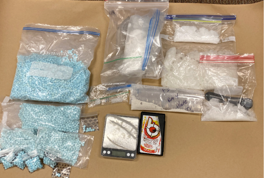 An assortment of items, including blue pills in bags, laid out on what looks like butcher paper