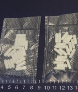 two baggies of white pills on a blue surface