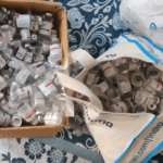 a cardboard box and tote bag full of glass vials